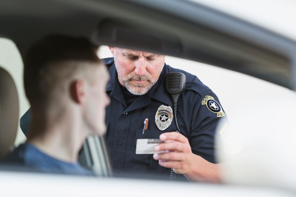 Hayes and Hayes - officer checking driver's license of man in car